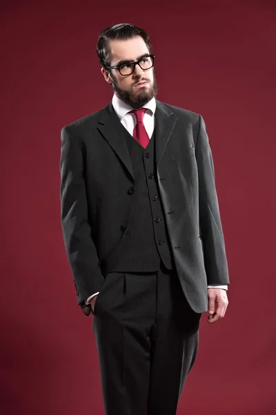 Retro 1900 fashion man with beard wearing grey suit red tie and — Stock Photo, Image