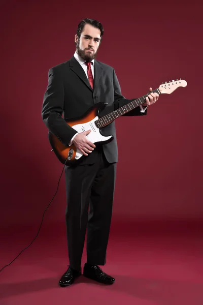 Moda retro muzyka mężczyzna z brodą sobie szary garnitur i krawat czerwony — Zdjęcie stockowe