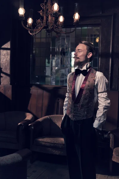 ひげのヴィンテージ 1900年ファッション男。古い木造の部屋に立っています。 — ストック写真