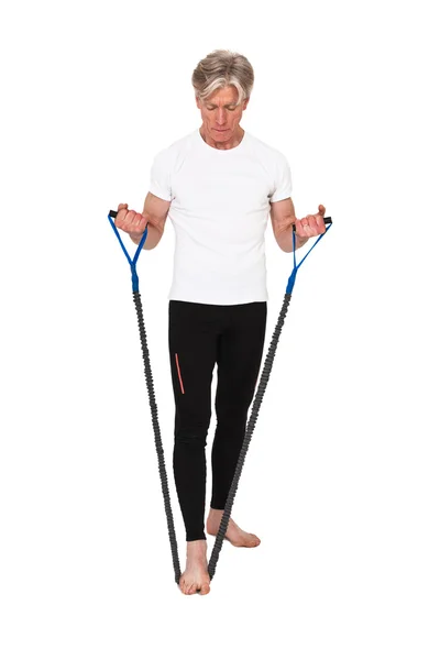 Senior fitness man exercising with blue elastics. Isolated on wh — Stock Photo, Image