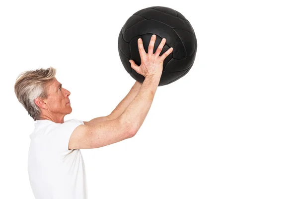 Hombre de fitness senior haciendo ejercicio con bola de pared negra. Aislado en — Foto de Stock