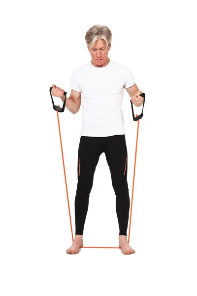 Homem de fitness sênior exercitando com elásticos laranja. Isolado em — Fotografia de Stock