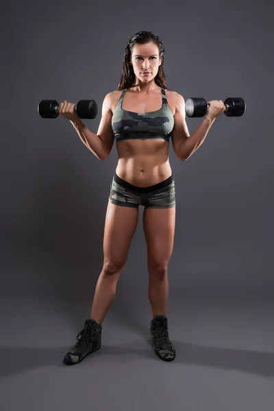 Fitness woman weight lifting with dumbbells. Wearing camouflage — Stock Photo, Image