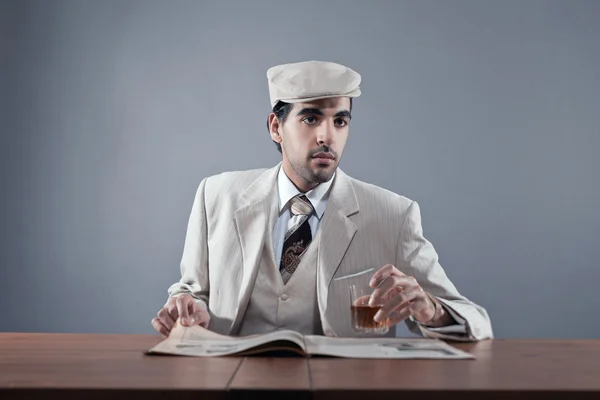 Mafia fashion man wearing white striped suit and cap. Sitting at — Stock Photo, Image