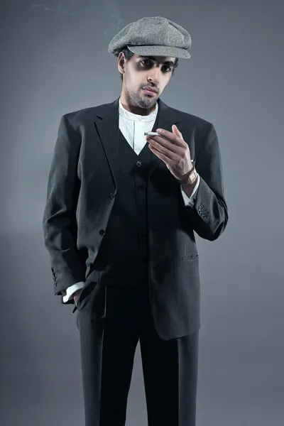 Homme de mode mafia portant costume rayé gris avec casquette. Tabagisme — Photo