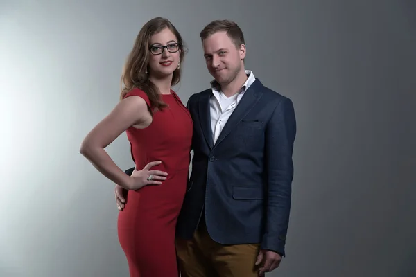 Casal de moda vestindo um vestido vermelho e casaco azul. Ela é weari. — Fotografia de Stock