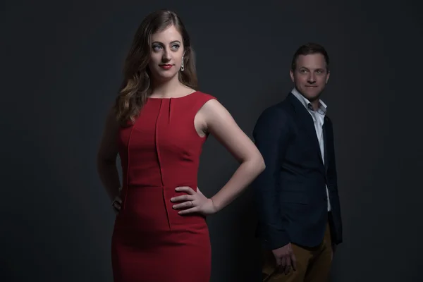 Fashion couple wearing a red dress and blue jacket. Young man an — Stock Photo, Image