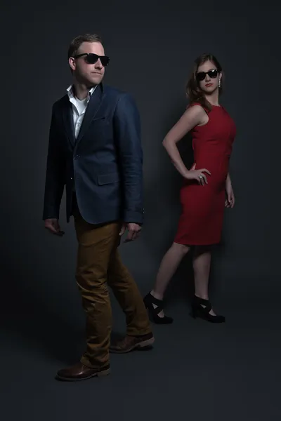 Modepaar in rotem Kleid, schwarzer Sonnenbrille und blauem Hemd — Stockfoto