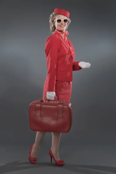Hostess bionda retrò indossa tuta rossa con cappuccio e occhiali da sole — Foto Stock