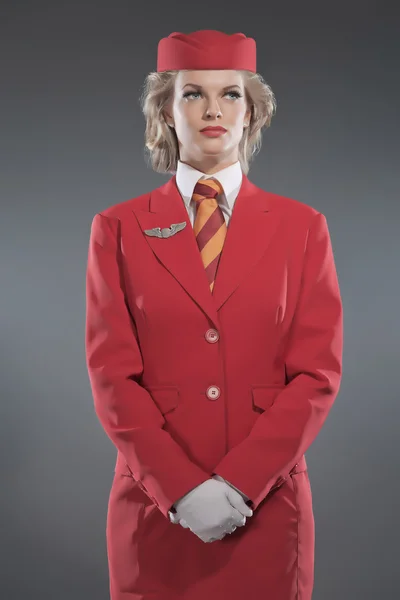 Retro loira aeromoça vestindo vermelho terno com listrado gravata e ca — Fotografia de Stock