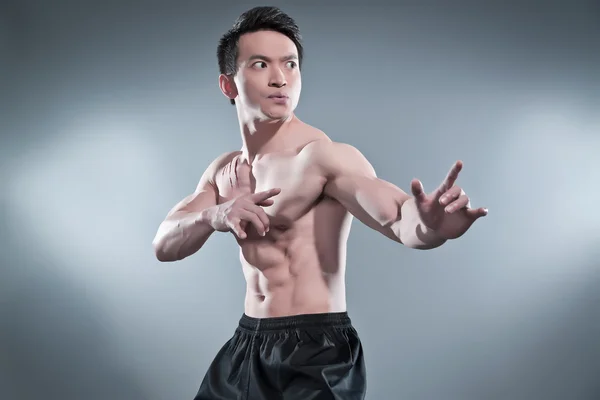 Muscled asiático kung fu homem em ação pose. listras de sangue em seu c — Fotografia de Stock