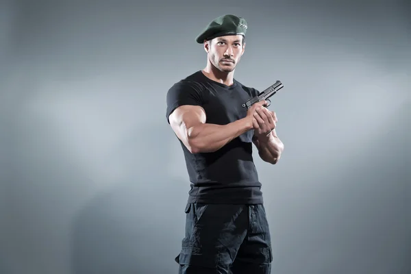 Comandante muscoloso azione eroe uomo con pistola indossare t-shirt nera — Foto Stock