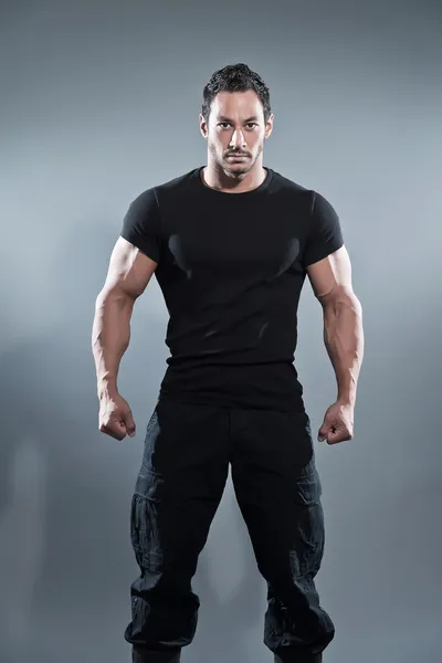 siyah gömlek ve pantolon giyen kaslı fitness adam savaş. Stüdyo