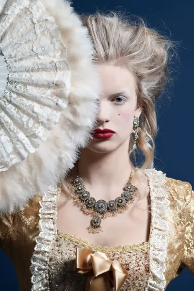 Femme de mode baroque rétro portant une robe en or. Je tiens un ventilateur. S — Photo