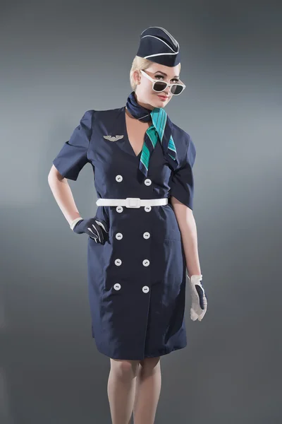 Retro blonde stewardess dragen blauwe pak glimlachen. dragen witte — Stockfoto