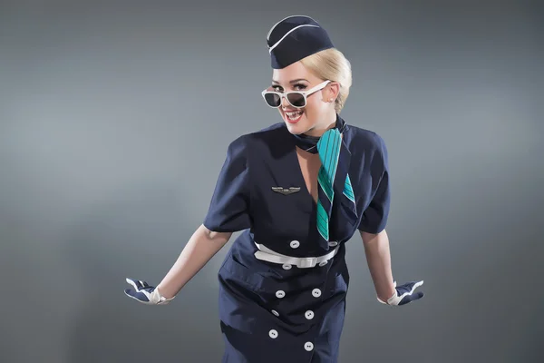 Retro blonde stewardess dragen blauwe pak glimlachen. dragen witte — Stockfoto