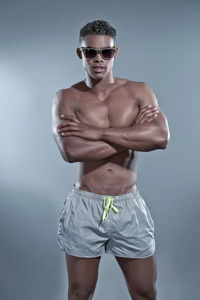 Uomo africano nero fitness con gli occhiali da sole. Costumi da bagno moda . — Foto Stock