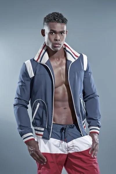 Schwarzafrikanischer Fitness-Mann trägt blaue Jacke und gestreifte Shorts — Stockfoto