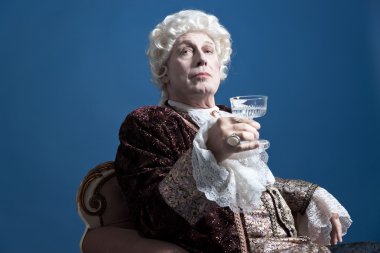 Beyaz peruk oturan bir şarap kadehi elinde olan Retro Barok adam
