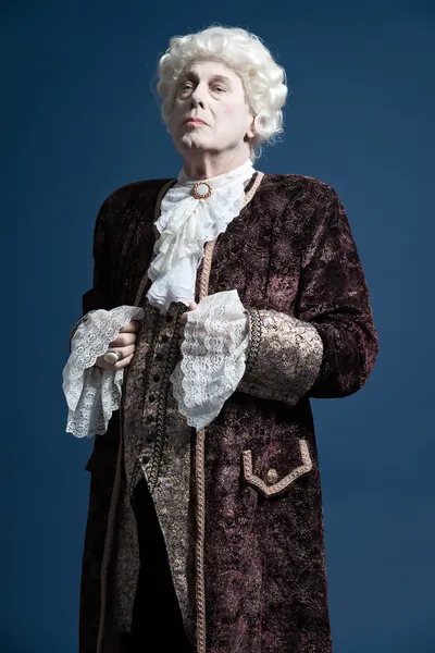 Retro barokke man met witte pruik permanent en op zoek arrogant. — Stockfoto