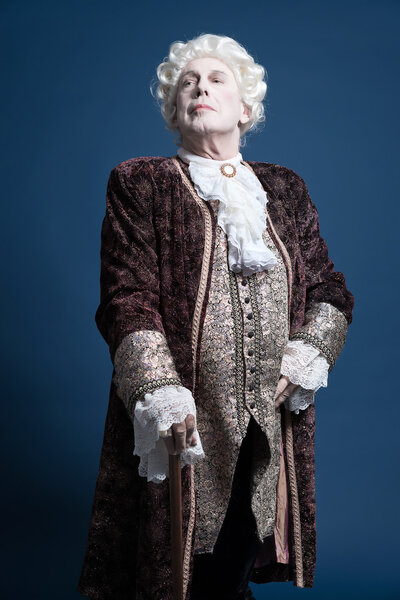 Retro baroque man with white wig standing with walking stick arr