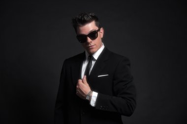 Retro ellili moda erkek takım elbise ile siyah güneş gözlüğü takıyor ve