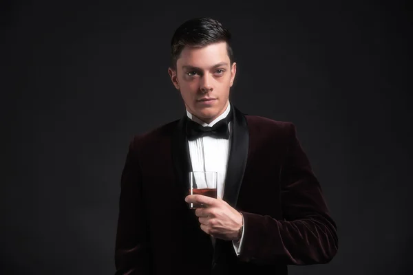 Well dressed good looking business man holding glass of whiskey. — Stock Photo, Image