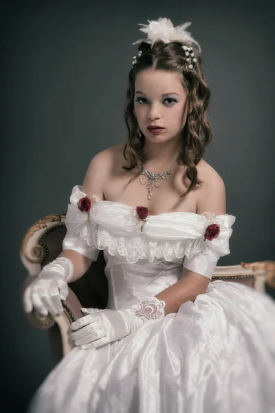 Retro victorian fashion woman wearing white dress. Sitting on an — Stock Photo, Image