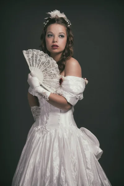 Femme de mode victorienne portant une robe blanche. Je tiens le ventilateur. Studio — Photo