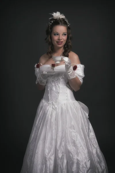 Victorian fashion woman wearing white dress. Holding porcelain t — Stock Photo, Image