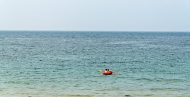 Yalnız kırmızı kürek tekne turist Okyanusu ile.