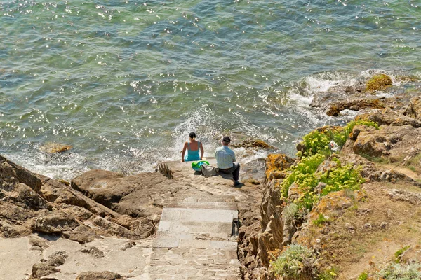 Τουρίστες που κάθεται πάνω σε βράχους κοντά στον ωκεανό. Βρετάνη. Γαλλία. — Φωτογραφία Αρχείου