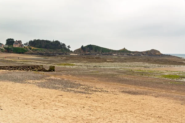 Praia com casa e céu nublado. Erquy. Bretagne. França . — Fotografia de Stock