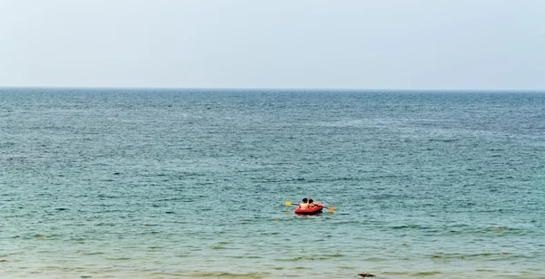 Barco a remo vermelho solitário com turistas no oceano . — Fotografia de Stock