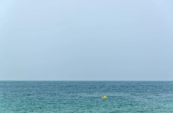 Einsamer Kanufahrer mit gelbem Kajak im Ozean. — Stockfoto
