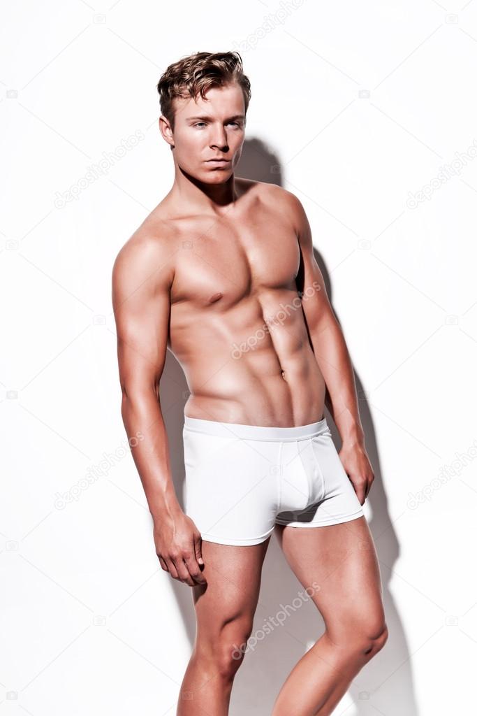 Male muscled underwear model wearing white shorts. Blonde hair. 