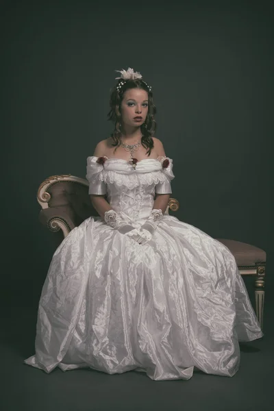 Retro victorian fashion woman wearing white dress. Sitting on an — Stock Photo, Image