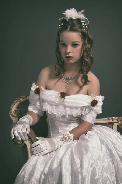 Retro victorian fashion woman wearing white dress. Sitting on an — Stock Photo, Image