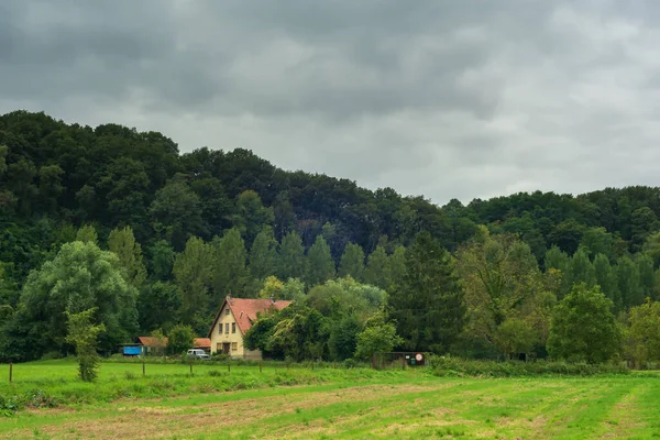 Dům Terénním Vozidlem Okraji Kopcovitého Lesa Pod Tmavou Zataženou Oblohou — Stock fotografie