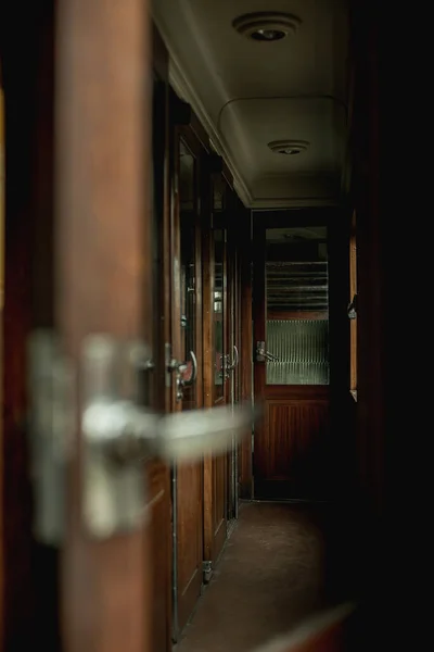 Open door in an interior of a vintage train compartment.