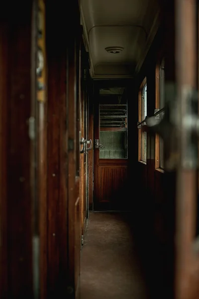 Open door in an interior of a vintage train compartment.