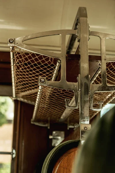 Empty luggage rack in a vintage train compartment.