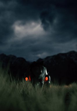 Car and wolf on prairie with mountains under a dark cloudy sky at twilight. 3D render.
