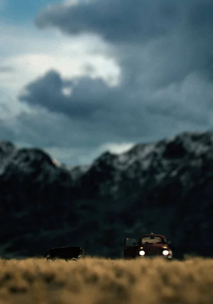 Vintage car and wolf on prairie with mountains under a dark cloudy sky. 3D render.
