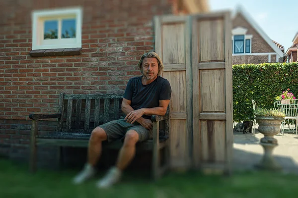 Blond Man Black Shirt Green Shorts White Sneakers Sits Bench — Stockfoto