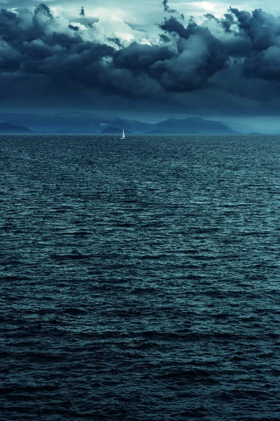 Oceano Com Veleiro Montanhas Horizonte Sob Céu Escuro Nublado — Fotografia de Stock