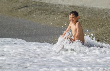 Denizde oynayan çocuk