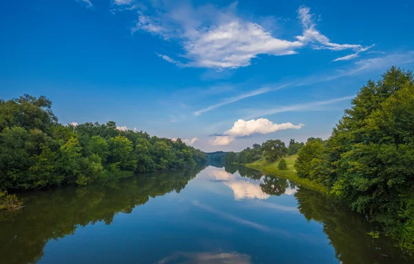 Letní řeka s jasně modrou oblohou a mraky — Stock fotografie