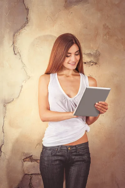 Giovane donna attraente con computer portatile vicino al muro — Foto Stock