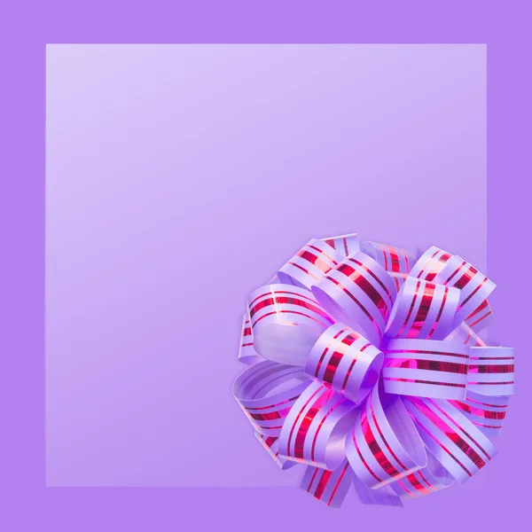 Подарочный бант на фиолетовом фоне — стоковое фото